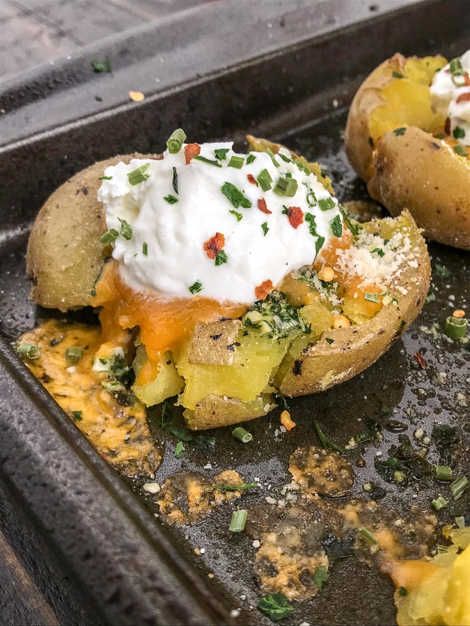 Crispy Loaded Garlic Smashed Potatoes -  potatoes baked with garlic, parsley, onion powder, parmesan cheese and butter. Better than the traditional baked potato, easy to make, and truly the best way to serve potatoes if they are not in fry form! #potatoes #easy #sidedish #dinner | https://withpeanutbutterontop.com