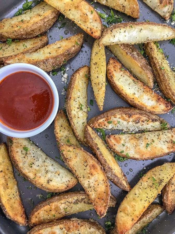 Crispy Baked Garlic Parmesan Potato Wedges - the best potato wedges you will ever try! Crispy on the outside, flaky on the inside, and flavorful throughout thanks to the garlic, parmesan seasoning! No tricks or extra work! #potatowedges #apppetizers #crispyfries | https://withpeanutbutterontop.com