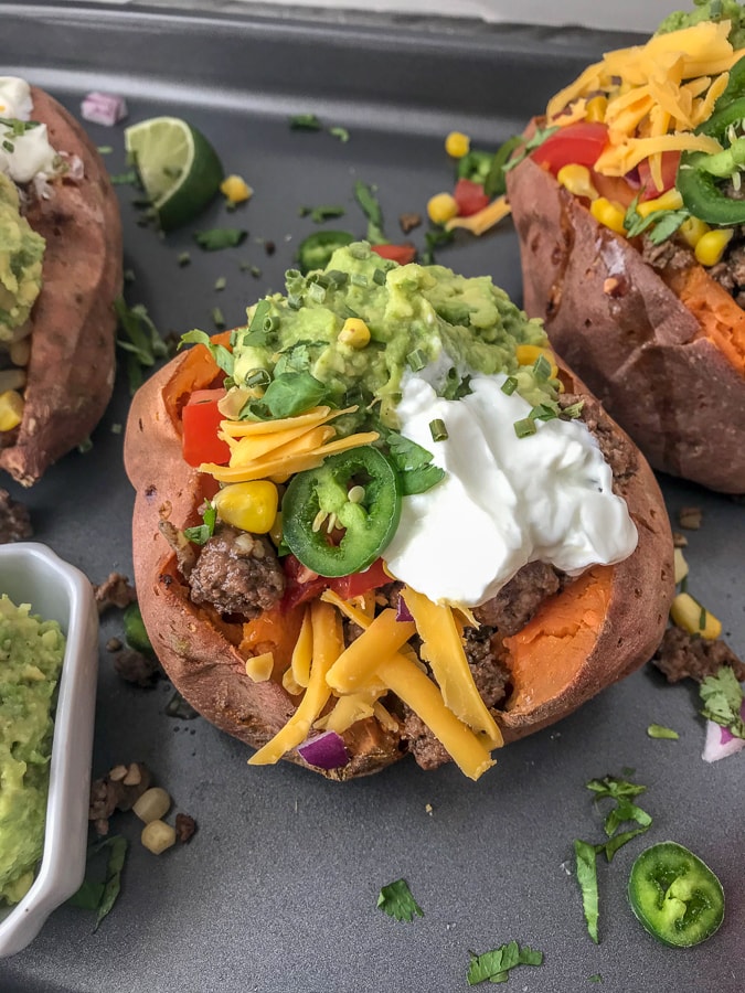 Taco Stuffed Sweet Potatoes - a simple and easy healthy spin on #TacoTuesday that you and your family are going to absolutely love! Full of flavor and perfect for those taco cravings! #taco #tacos #healthy #stuffedsweetpotatoes #tacostuffed | https://withpeanutbutterontop.com