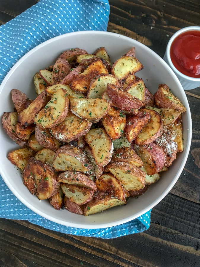 Super Crispy Garlic Parmesan Potato Bites - this is the perfect side dish to your dinner tonight! Easy to make, ready in 30-35 minutes, and sure to be a hit at your table! Crispy on the outside and light and fluffy on the inside like potatoes should be! #sidedish #crispypotatoes #ovenroastedpotatoes #baked | https://withpeanutbutterontop.com