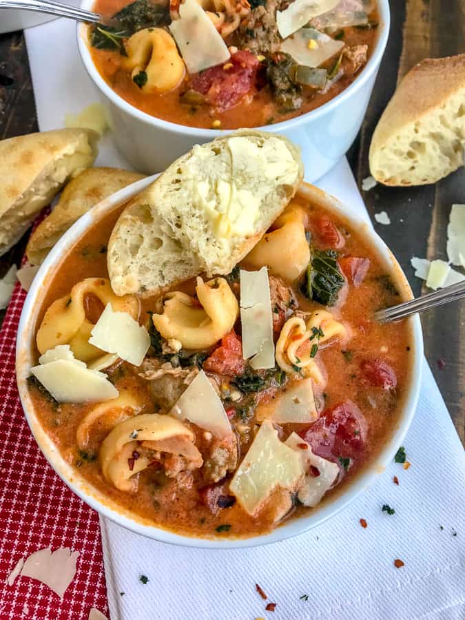 One Pot Sausage Tortellini Tomato Soup - a super delicious and easy recipe that is filled with turkey sausage, cheese tortellini, kale, and herbs in a delicious tomato base! Hearty, filling, and yummy! #soup #healthysoup #sausagetortellinisoup | https://withpeanutbutterontop.com